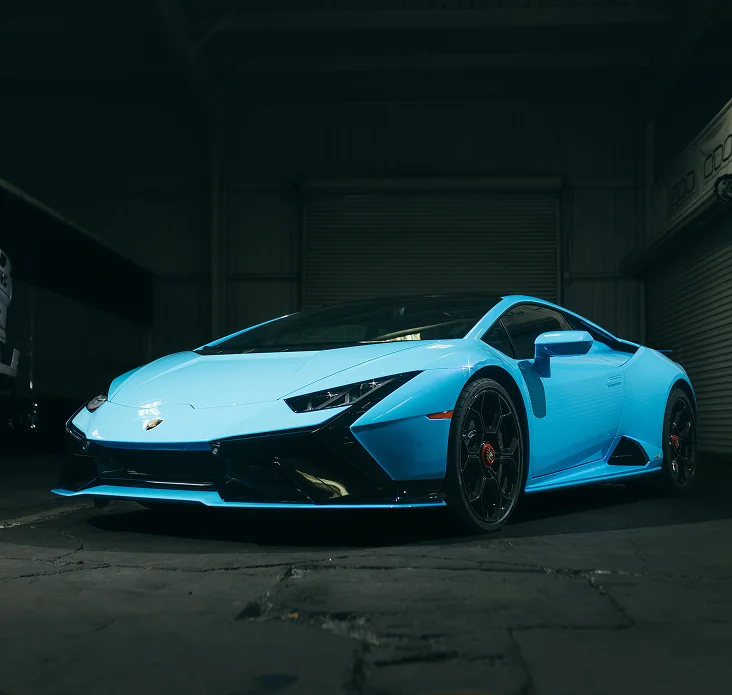 Sky blue Lamborghini featuring Colored PPF in a dark garage, highlighting high-gloss protective film and custom color wrap.